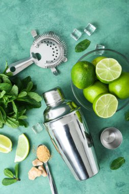 Grunge arkaplanı üzerine mojito hazırlamak için titretici, süzgeç ve malzemeler