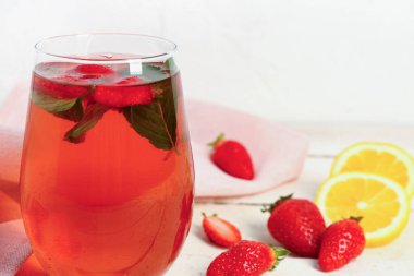 Beyaz masada bir bardak lezzetli çilek suyu.