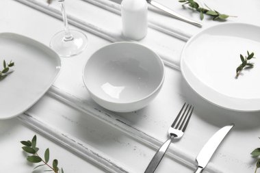 Beyaz ahşap zemin üzerinde şık masa ayarları ve mum