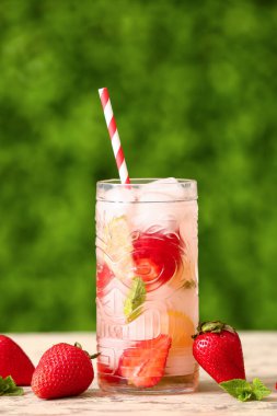 Dışarıdaki beyaz masada çilekli limonata.