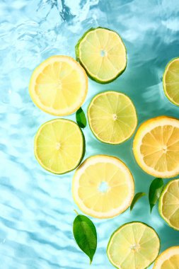 Mavi zemin üzerinde taze limon ve limon dilimleri