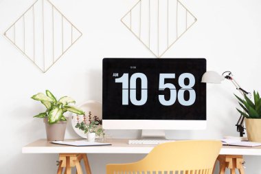 Işık ofisinde bilgisayar monitörü ve yapay tesisleri olan modern işyeri