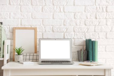 Boş dizüstü bilgisayarı ve yapay tesisi olan modern işyeri