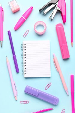 Mavi arkaplanda farklı kırtasiye malzemesi olan defter