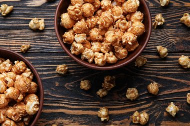 Tahta arka planda lezzetli patlamış mısır kaseleri