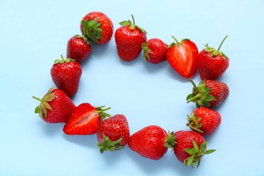 Mavi arka planda taze çileklerden yapılmış çerçeve