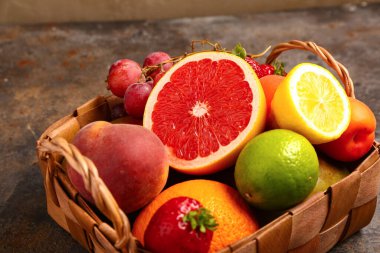 Siyah sepetin üzerinde farklı taze meyveler var.