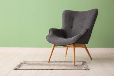 Yeşil duvarın yanındaki gri koltuk