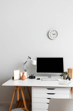 Modern bilgisayar ve ışık duvarının yanında fotoğraf makinesi olan şık bir iş yeri.