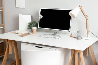 Işık duvarının yanında modern bilgisayarla rahat bir iş yeri