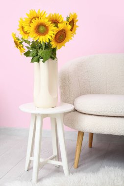 Oturma odasındaki masada vazo ve ayçiçekleri.