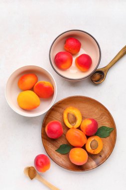 Beyaz arka planda tatlı kayısılar ve tabaklar