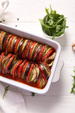 Beyaz ahşap arka planda lezzetli Ratatouille yemeği pişirmek.