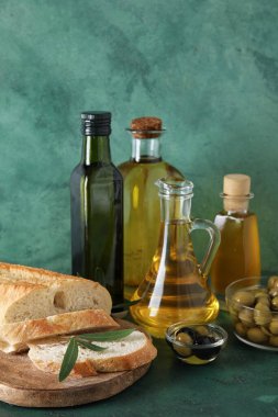 Yeşil zemin üzerinde taze zeytinyağı ve ekmek farklı bir bardak.