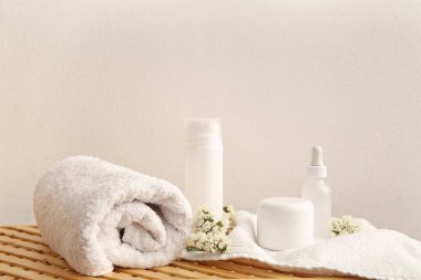 Beyaz duvarın yanındaki masada spa malzemeleri var.