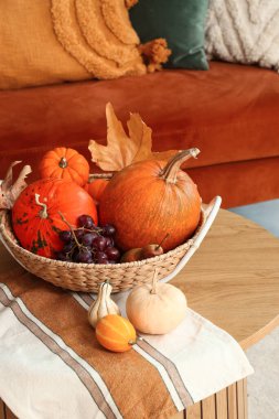 Oturma odasındaki masada balkabağı olan meyve sepeti, yakın plan.
