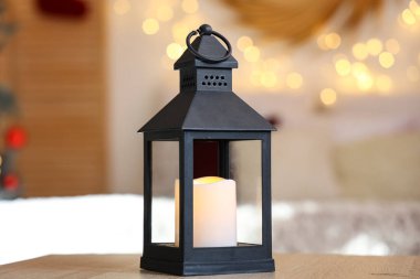 Yatak odasındaki masada yanan mum olan Noel feneri, yakın plan.