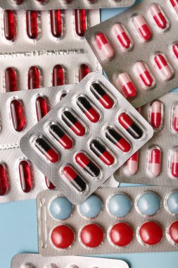 Mavi arka planda farklı haplar içeren kabarcık paketleri