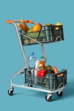 Mavi arka planda yiyecek dolu alışveriş arabası.