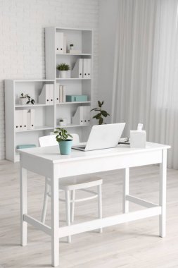 Doctor's workplace with laptop in modern clinic