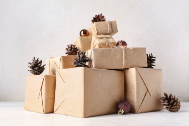 Beyaz arka planda bir sürü hediye kutusu ve Noel topları olan çam kozalakları.