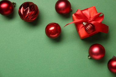 Yeşil arka planda hediyeli kırmızı Noel baloları