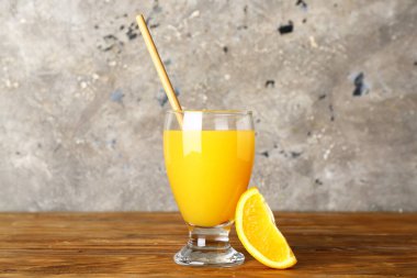 Tahta masada bir bardak taze portakal suyu.