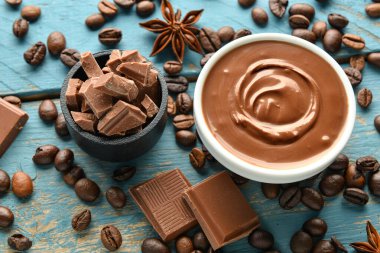 Mavi ahşap arka planda lezzetli eritilmiş çikolatalı kompozisyon