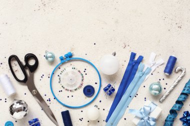 Işık arka planında dikiş malzemeleri ve Noel süslemeleri olan kompozisyon