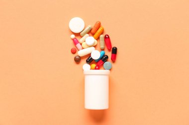 Şişeli kompozisyon ve renkli arka planda haplar