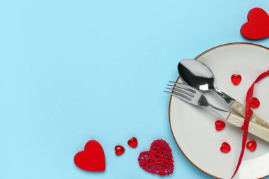 Mavi arka planda kurdeleli ve kalpleri olan güzel bir masa. Sevgililer Günü kutlaması