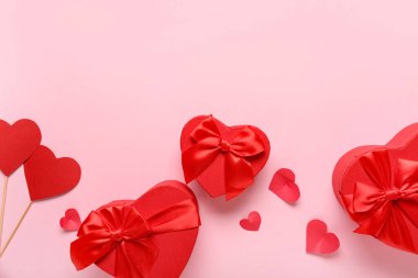 Hediye kutuları ve pembe arka planda kağıt kalpler. Sevgililer Günü kutlaması