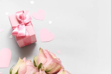 Hediye kutusu, gül buketi ve gri arka planda kalpler, yakın plan. Sevgililer Günü kutlaması