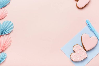 Kağıt kalpli kurabiyeler ve pembe arkaplanlı zarf. Sevgililer Günü kutlaması