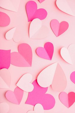Paper hearts on pink background. Valentine's Day celebration