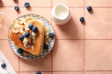 Kalp şeklinde leziz krepler, bej kaplamalı yabanmersini, fındık ve süt tabağı. Sevgililer Günü kutlaması