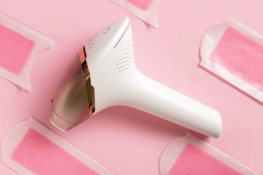 Pembe arka planda balmumu şeritli modern fotoepilatör