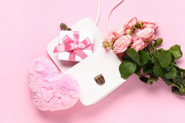 Çantanın içinde uygun bir kutu, kalp ve pembe arka planda bir buket gül. Sevgililer Günü kutlaması