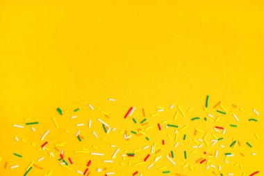 Turuncu arka plana serpiştirilmiş tatlı renkli serpintiler