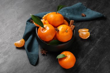 Tarçınlı bir kase tatlı mandalina ve siyah arka planda yıldız anason.