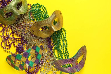 Sarı arka planda Mardi Gras kutlamaları için dekorlu karnaval maskeleri