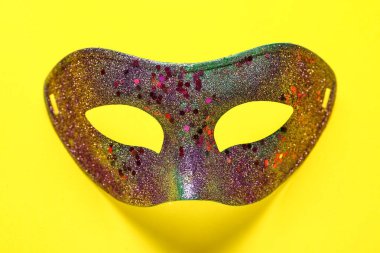 Sarı arka planda Mardi Gras kutlaması için parlak karnaval maskesi