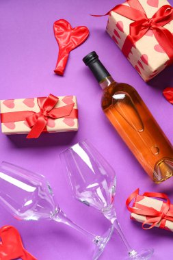 Gözlüklü bir şişe beyaz şarap, mor arka planda hediyeler ve balonlar. Sevgililer Günü kutlaması