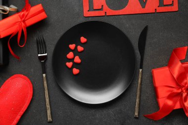 Sevgililer Günü için güzel bir masa. Siyah grunge arka planında sevgi, hediyeler ve kalplerle dolu.