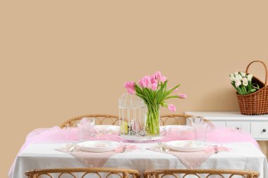 Uluslararası Kadınlar Günü kutlamaları için renk duvarına yakın yemek masası ve lale çiçekleri