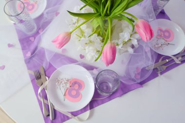 Light dining table served for International Women's Day celebration, closeup