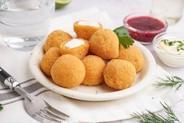 Hafif arka planda lezzetli kızarmış mozzarella topları olan tabak, yakın plan.