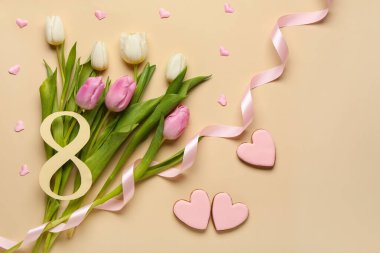 Sekizinci figür lale çiçekleri ve bej arka planda kurabiyeler olan kağıttan yapılmış. Uluslararası Kadınlar Günü kutlamaları