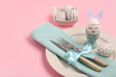 Pembe arka planda Paskalya yumurtaları olan güzel bir masa.