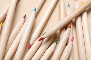 Bej arkaplanda renkli kalemler, yakın plan